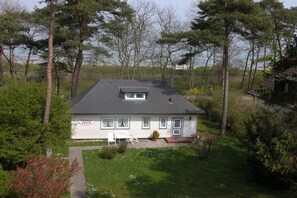 A single-story house with a dark roof, a small porch, and a visible name sign. - Holiday home with 3 bedrooms (Timmendorfer Strand)
