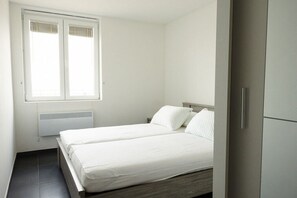 A bedroom with a bed, a window, and a wardrobe. - Holiday home in Middelkerke with Wi-Fi (Middelkerke)