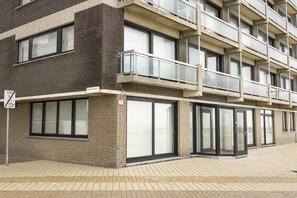 Un immeuble à plusieurs étages, doté d’une façade en briques, de grandes fenêtres et de balcons.