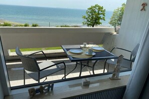 A balcony with a table set for two, overlooking a body of water. - Dream view "Nautilus" (Sierksdorf)