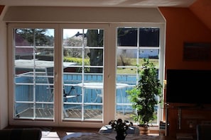 A room with a large sliding glass door leading to an outdoor patio area. - House Elke Apartment 1st Floor (Wieck a. Darß)