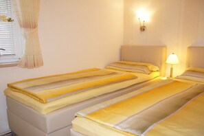 A room with two beds, each with a headboard and a bedside lamp. - Holiday apartment with 1 bedroom (Travemünde)