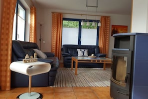 Una sala de estar con un sofá, una mesa de centro, una chimenea y una lámpara.