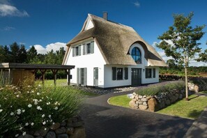 A modern house with a thatched roof, a stone pathway, and a well-maintained garden. - ||------------------------Reed Warbler 45---------------------|| (Fuhlendorf)