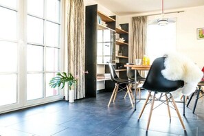Un espace repas moderne avec une table, des chaises et une plante en pot.