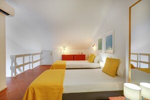 A hotel room with two beds, a red dresser, a small table, and a mirror. - Casa da Galé Pool Terrace (Albufeira)