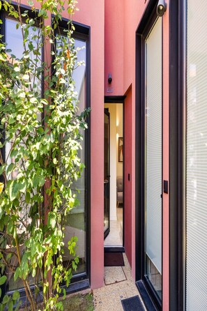 A modern building with a red facade, large windows, and a visible door. - Skylight Loft Terracotta Collection (Porto)