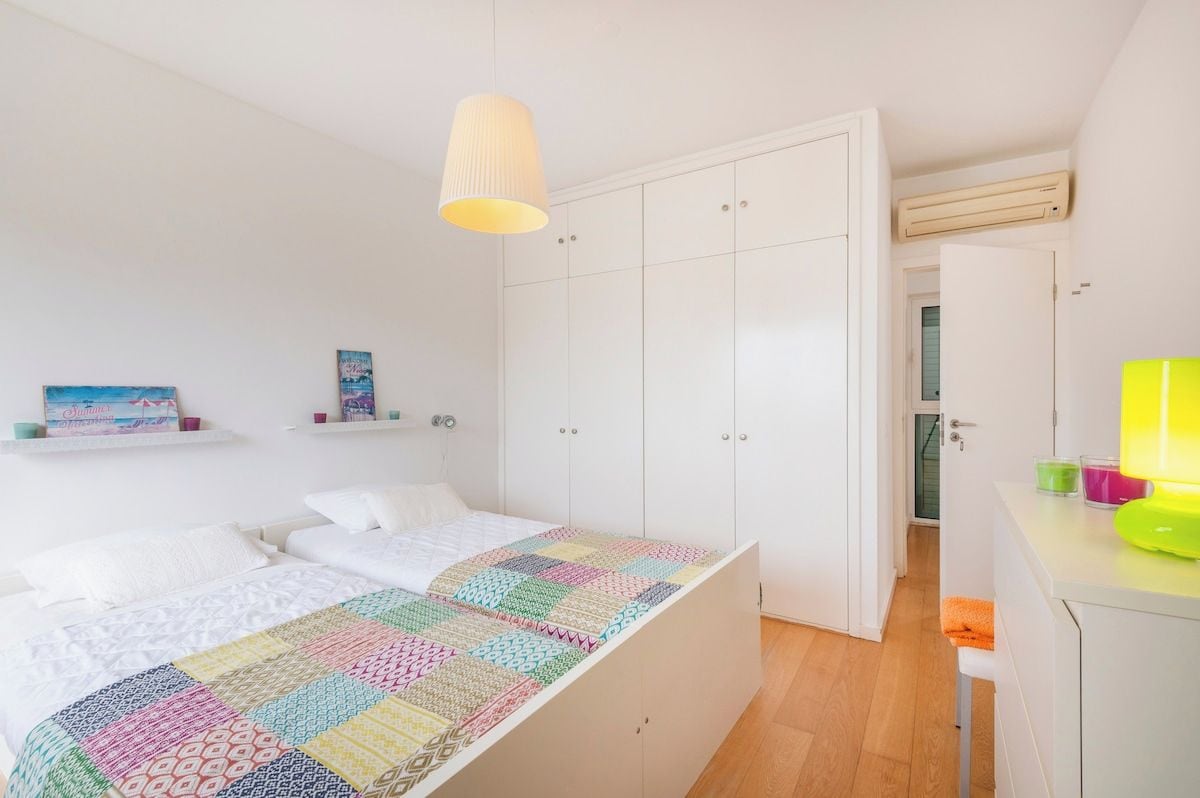 Une chambre à coucher comprenant un lit, une armoire, un bureau et une lampe suspendue.