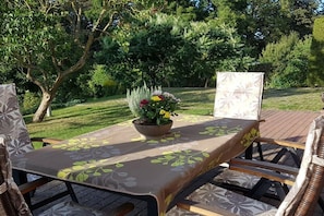 An outdoor dining area with a table set for two, surrounded by wicker chairs. - with direct lake access (Trams)