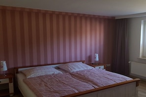 A bedroom with a bed, two bedside tables, and a window with curtains. - with direct lake access (Trams)