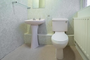Ein Badezimmer mit Waschbecken, Toilette und einer Duschkabine aus Glas.