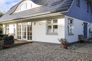 A single-story house with a white exterior, a grey roof, and a number '2c' on the wall. - House on the Bodden shore (Born a. Darß)