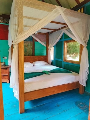 A four-poster canopy bed with a wooden frame and white bedding, set in a room with green walls and a blue floor. - Alaya Ecolodge (Buleleng)
