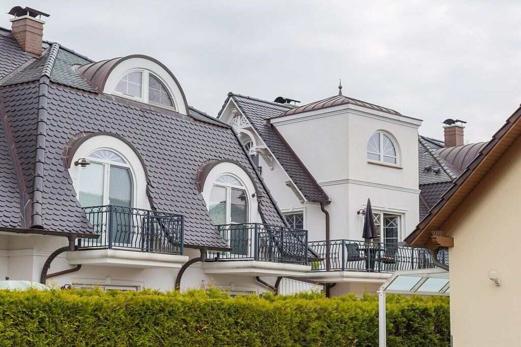 A row of residential buildings with pitched roofs and balconies.
