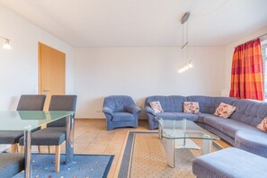 A living room with a glass dining table, two sofas, and a coffee table. - Holiday apartment with 2 bedrooms (Ostseebad Boltenhagen)