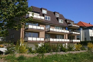 A multi-story residential building with balconies, a brick facade, and a clear sky. - Holiday apartment with 2 bedrooms (Ostseebad Boltenhagen)