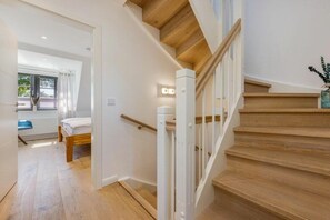 A staircase with wooden steps and white railings leading to an upper floor. - Holiday home with 3 bedrooms (Ostseebad Zingst a Darß)