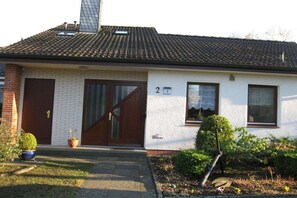 A single-story building with a tiled roof, two doors, and a small window. - Apartment in Norderstedt with swimming pool (Norderstedt)