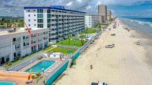 A hotel with multiple floors, a swimming pool, and a beachside location. - #203 Curran Shores N. 2/2 Oceanfront Condo (Daytona Beach Shores)