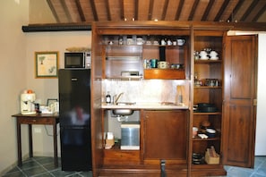 A compact kitchen with a built-in microwave, a coffee maker, and a sink. - OASI LIGNANA Apartments (PESCIA)