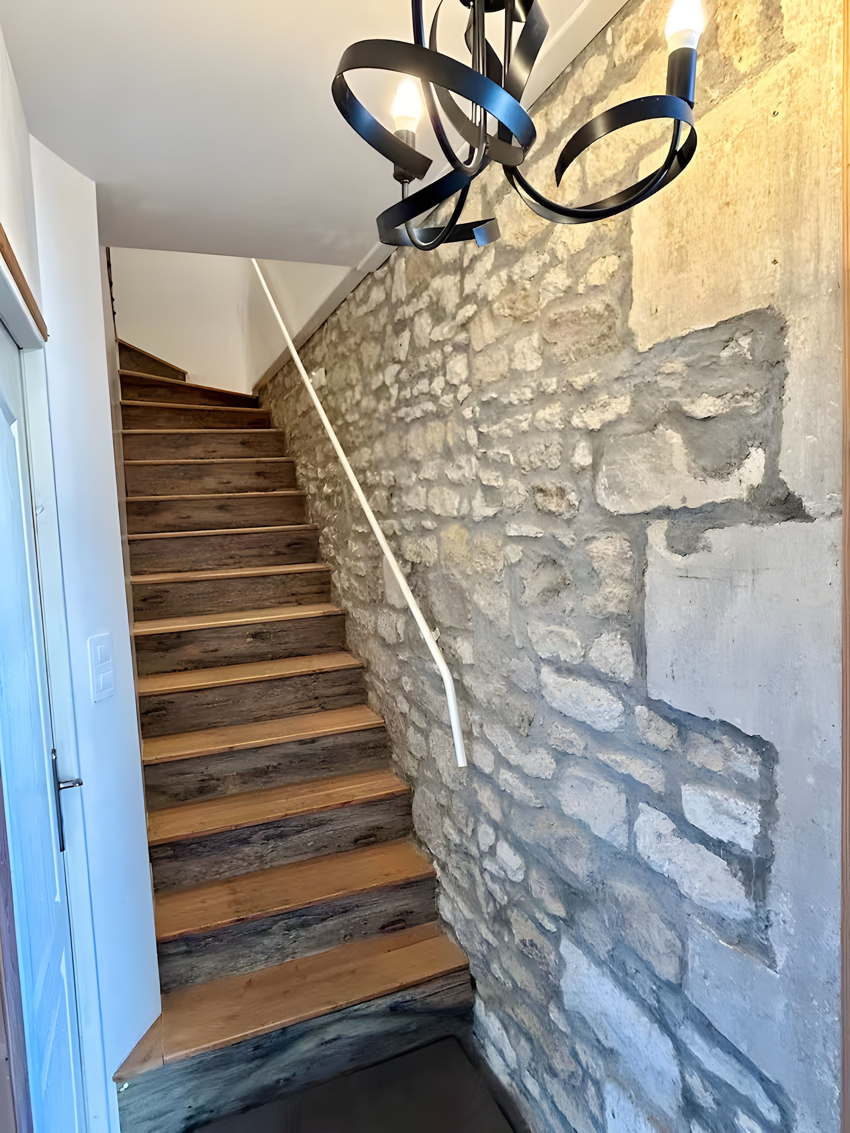 A staircase with wooden steps and a stone wall.