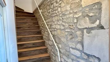 A staircase with wooden steps and a stone wall.