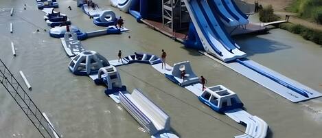 Parque acuático con múltiples toboganes y embarcaciones.
