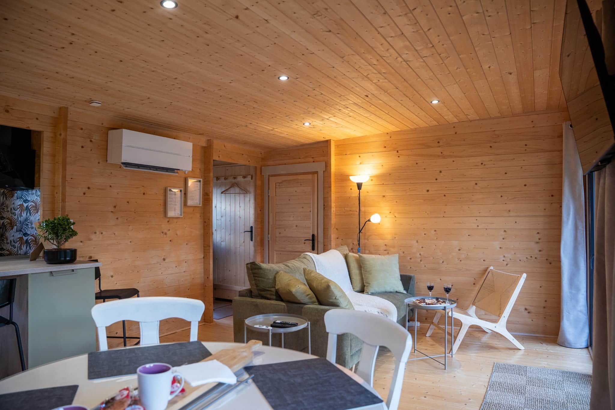Ein gemütliches Blockhaus-Interieur mit Essbereich, einer Couch und einer Lampe.
