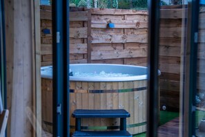 A wooden outdoor hot tub with a step leading up to it, surrounded by a wooden fence. - "Chalet, Charming Vacation Home" (Camors)