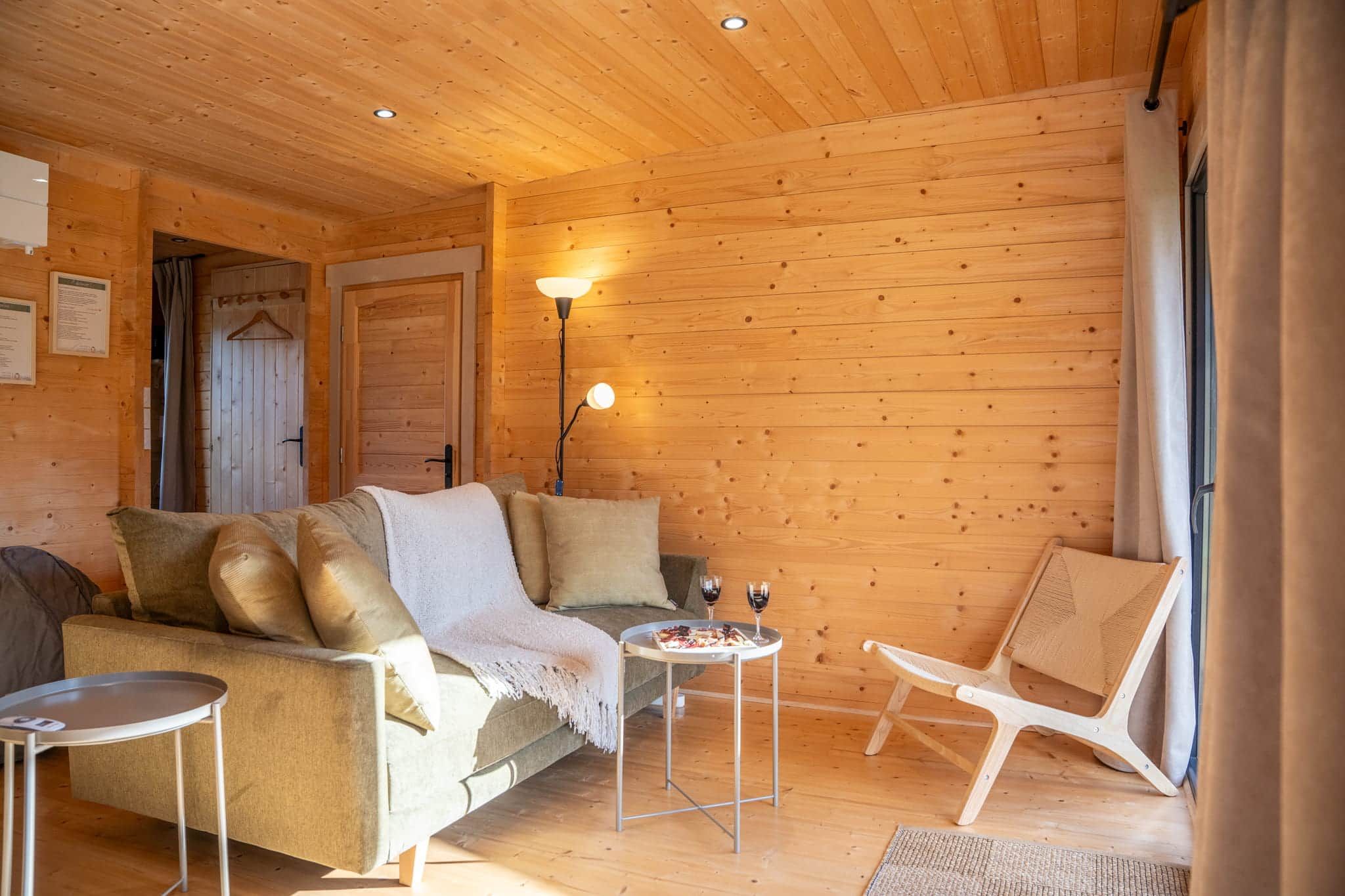 Ein gemütliches Zimmer mit einer Couch, einem kleinen Tisch mit Getränken und einem Sessel.