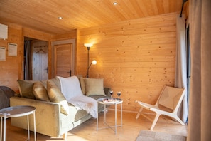 Une pièce confortable avec un canapé, une petite table avec des boissons et un fauteuil.