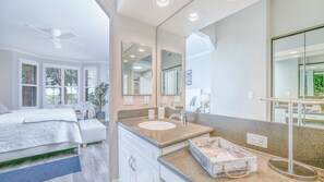 Un baño moderno con un espejo grande, un lavamanos y tocador.