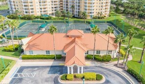 A hotel with a central courtyard, palm trees, and a tennis court. - 2306 Harbour Village (Ponce Inlet)