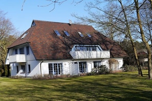 A two-story house with a sloped roof, multiple windows, and a balcony. - Oak Park W 4.2||Ostseebad Prerow (Ostseebad Prerow)