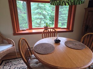 A dining area with a round wooden table, two woven placemats, a candle holder, and chairs. - Country house with rustic charm. Tastefully decorated. Photos available upon request (Saint-Sauveur)