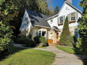 A two-story house with a stone facade, a stone pathway leading to the entrance, and a well-maintained lawn. - Country house with rustic charm. Tastefully decorated. Photos available upon request (Saint-Sauveur)