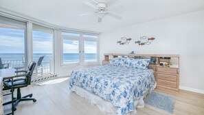 A bedroom with a bed, a desk, a chair, a dresser, and a view of the ocean. - #305 Blue Surf 2/2 Oceanfront Traffic Free Beach (Daytona Beach Shores)