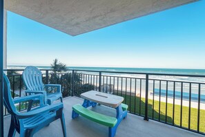 A balcony with a view of the beach, a table, and two chairs. - #305 Sandcastle Oceanfront 3/2 Traffic Free Beach Ponce Inlet (Ponce Inlet)
