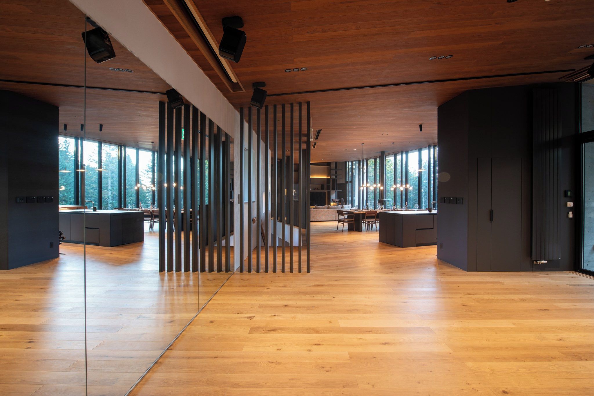 A spacious interior with a wooden floor, large windows, and a modern design.