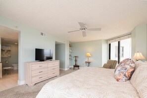 A bedroom with a bed, a television on a dresser, a ceiling fan, and a window with blinds. - #306 Seychelles 2/2 Southeast Corner Oceanfront Condo on Traffic Free Beach (Daytona Beach Shores)