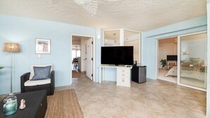 A living room with a television, a sofa, and a dining area in the background. - 3202 Towers in Ponce Inlet, FL (Ponce Inlet)