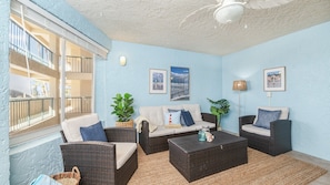 A sunlit room with a sofa, two armchairs, a coffee table, and a floor lamp. - 3202 Towers in Ponce Inlet, FL (Ponce Inlet)
