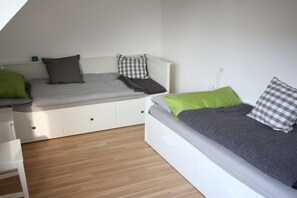 Une chambre avec un lit en mezzanine, un bureau et une chaise.