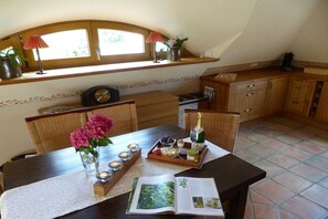 A dining area with a table set for two, featuring a book, candles, and a bottle of champagne. - at the gateway to Fischland (Ribnitz-Damgarten)