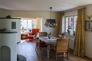 A dining area with a table, chairs, and a hanging light fixture. - Holiday apartment in Wieck with swimming pool (Wieck)