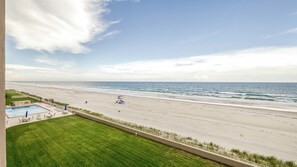 A beach view from a balcony with a swimming pool and lounge chairs. - #402 Sandcastle 2/2 Oceanfront Condo Traffic Free Beach (Ponce Inlet)
