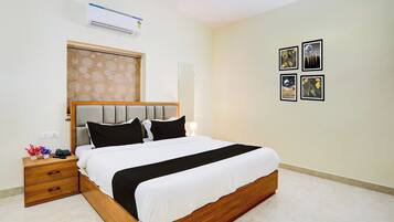Habitación de hotel con cama, mesita de noche y aire acondicionado de pared.