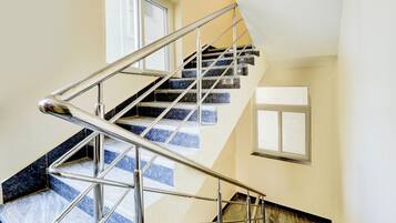 Uma escadaria em espiral com guarda-corpos de metal e vista para o andar superior.