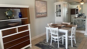 A dining area with a white table set for four, surrounded by white chairs. - #405 Sandcastle 2/2 Oceanfront Condo Traffic Free Beach (Ponce Inlet)