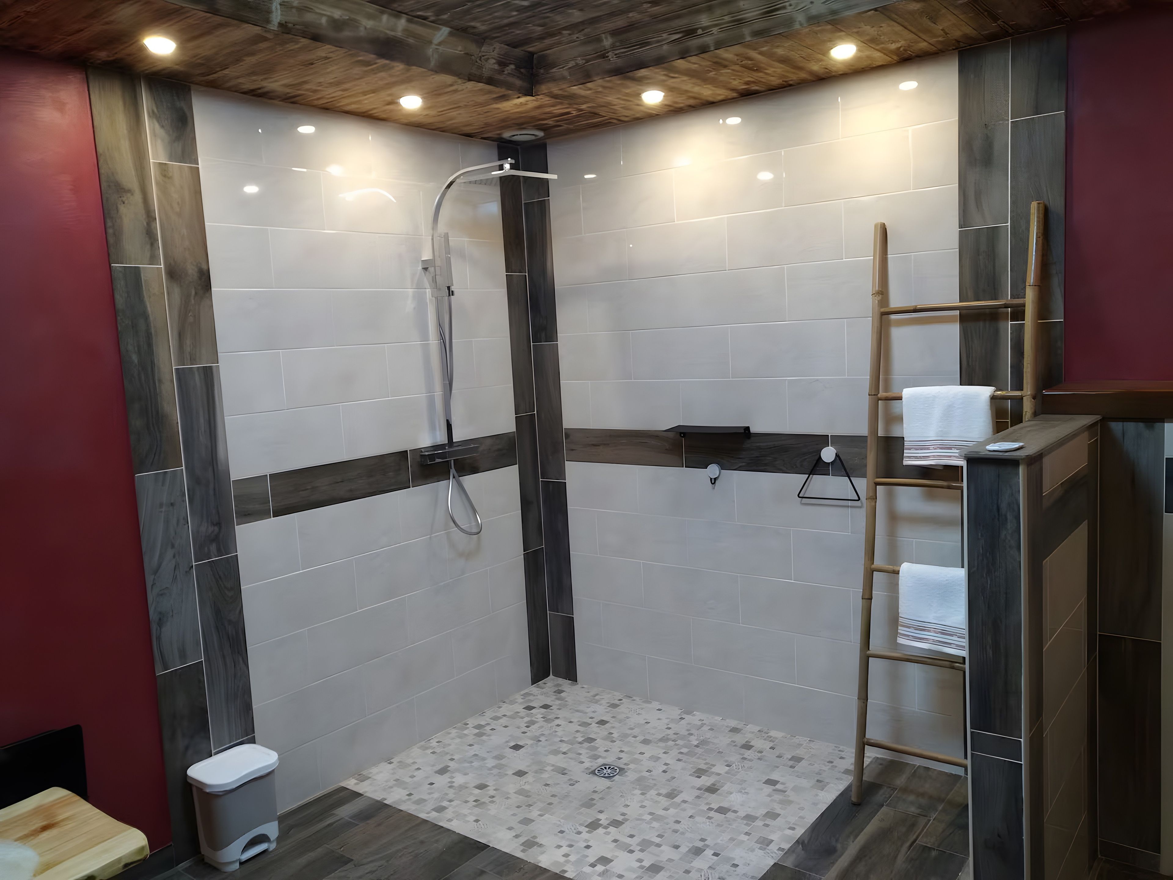 Un espace douche doté d’un plafond en bois, de murs carrelés et d’un petit tabouret en bois.